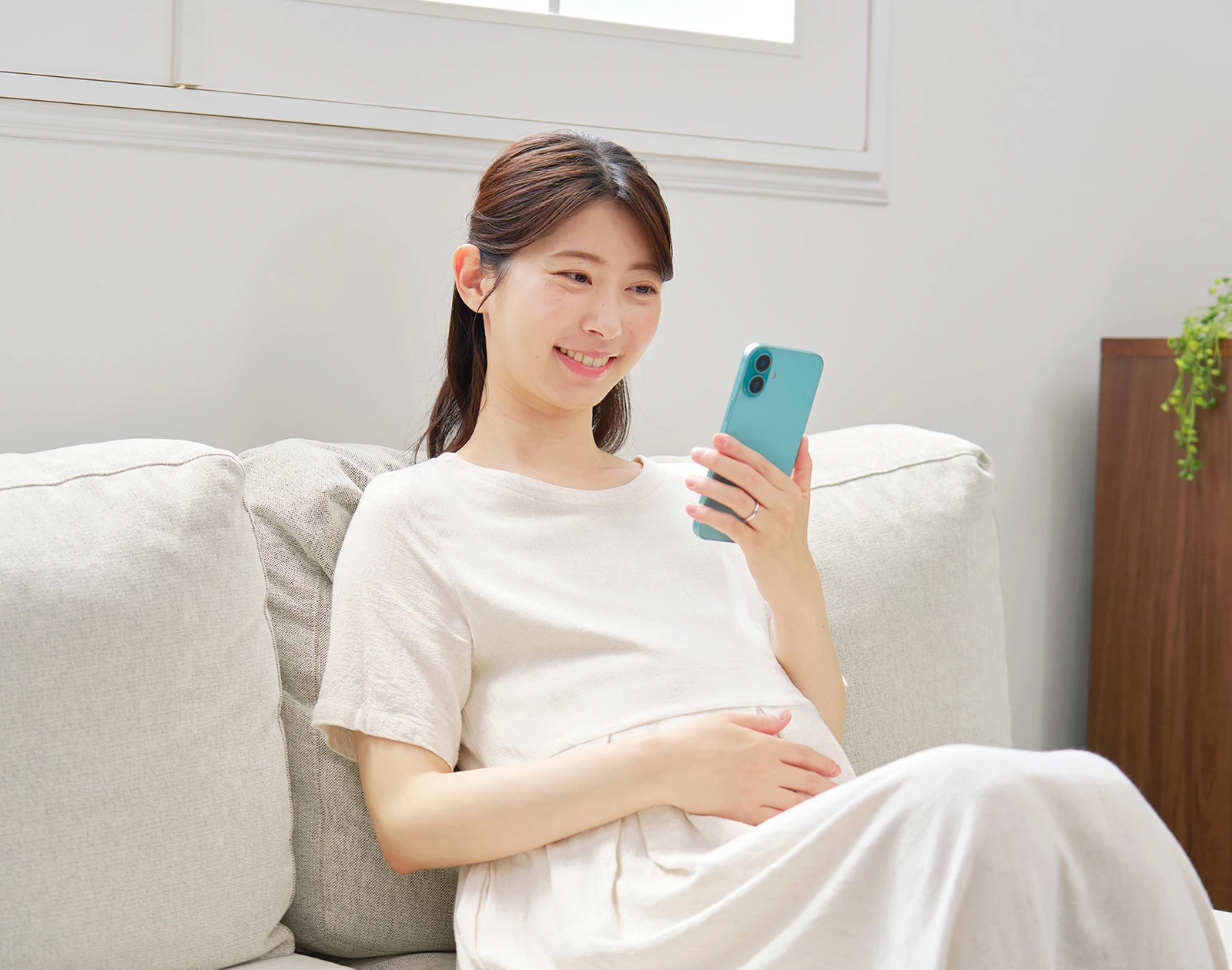 ベビーパッドプレママ - 通院されている妊婦さんがスマホを見ている様子